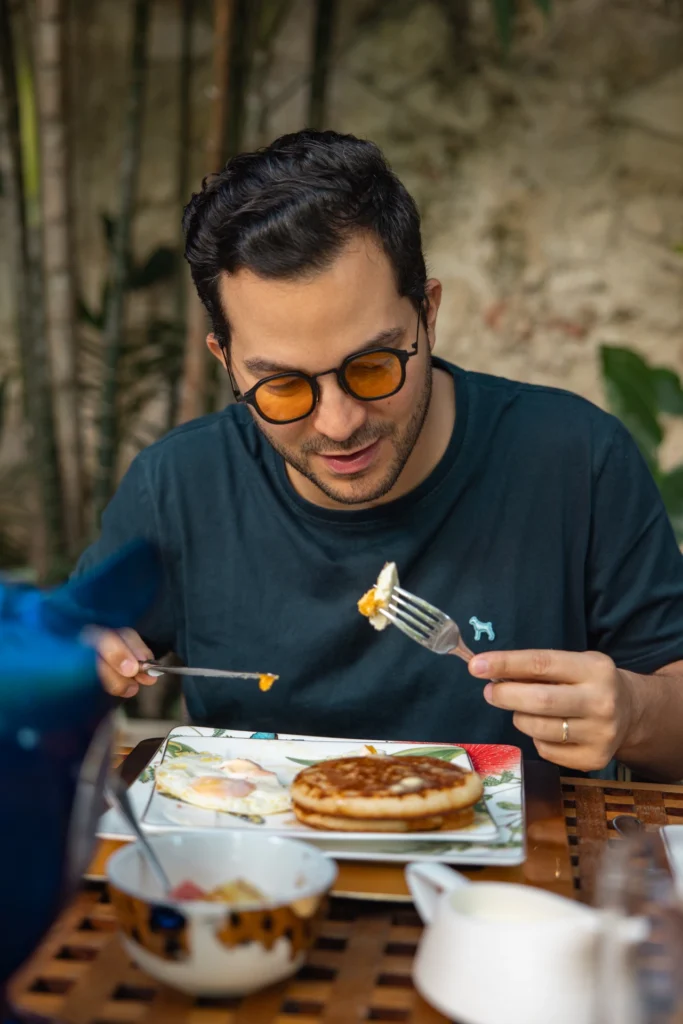 Huésped disfrutando del desayuno en el jardín de Casa Santiago Botero